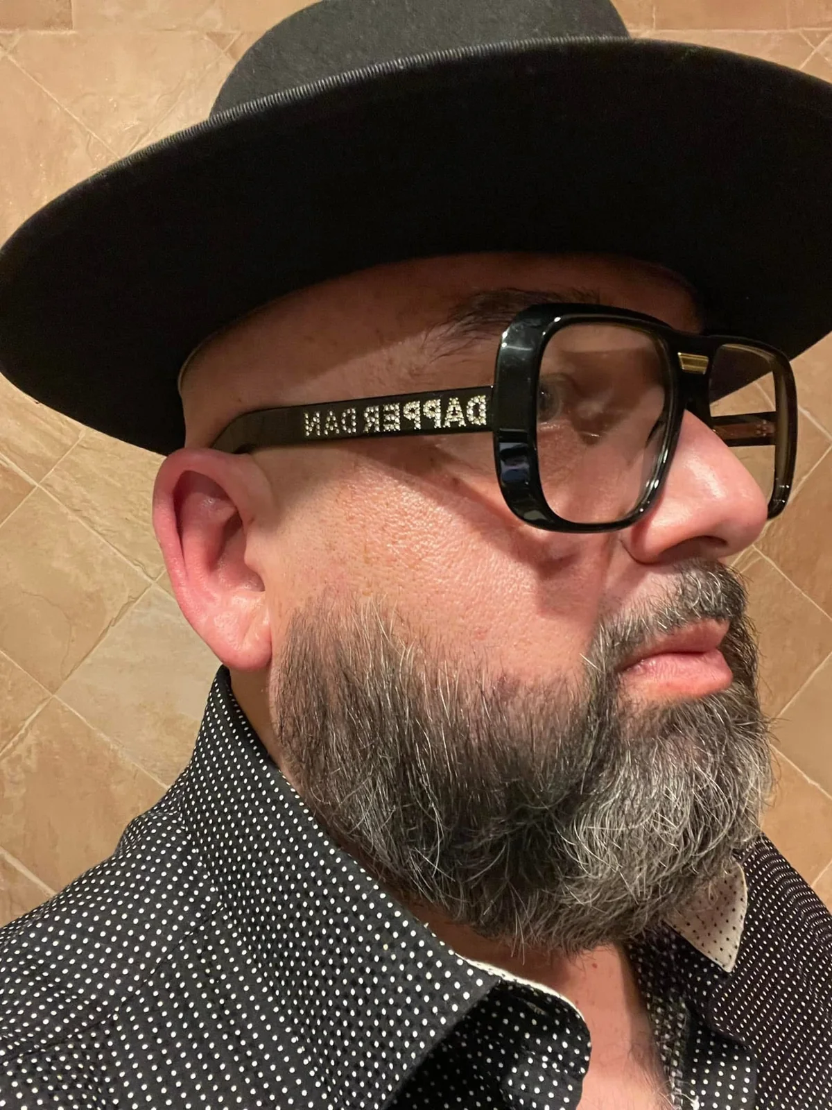 Bobby Mitchell wearing a black hat and statement glasses